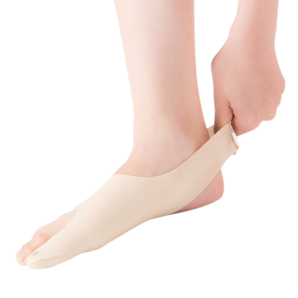 Person wearing a beige ankle support brace on a white background