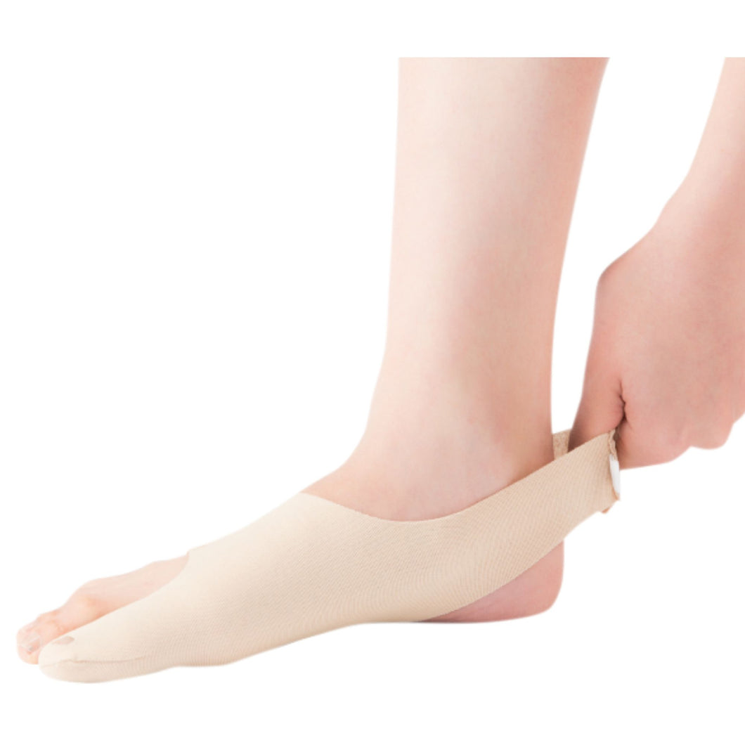 Person wearing a beige ankle support brace on a white background